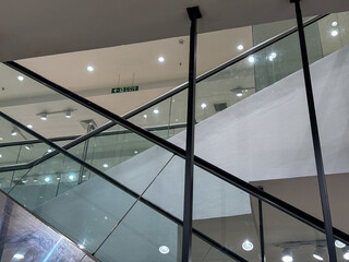 A glass staircase with a green sign on it
