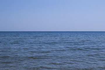 Blue sea to horizon with blue sky.