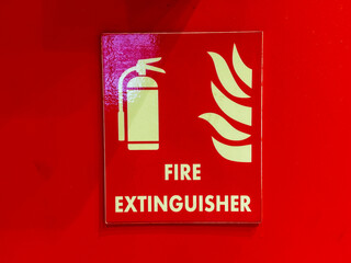A red sign with a fire extinguisher on it