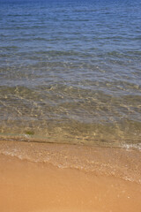 Fototapeta na wymiar Close-up of a wave of clear water on a sandy beach.