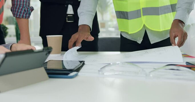 Close up of team engineers where one of them showing ready building plan to his successful man chief in office room