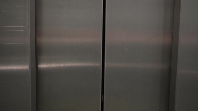 Elevator gracefully ascends, transporting viewers to new heights. The doors gently slide open, revealing an interior of a building. 