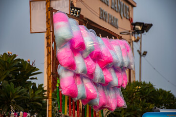A seller selling pink and white cotton candy.