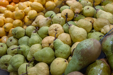 Assortment of fresh fruits arranged in the grocery store on the counter. Oranges, Lemons pears, apples on food market rack. Variety of fruits sold in the store. Side view. Selective focus. 