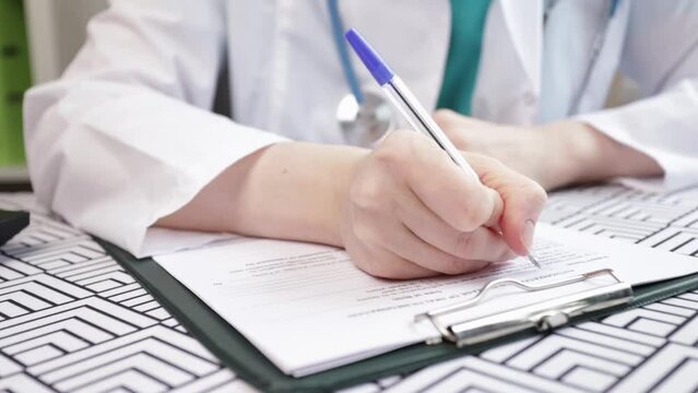 Doctor fills out medical documents, signing patient prescription, healthcare service