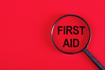 First Aid is the first and immediate assistance given to any person, text concept under magnifier - obrazy, fototapety, plakaty