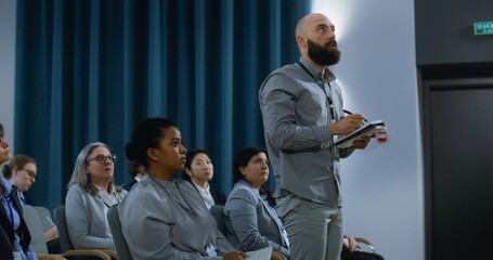 Caucasian male media representative stands up and asks questions during interview. Multiethnic...