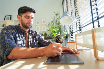 Man using a tablet pensively in a serene office space, bathed in sunlight filtering through...