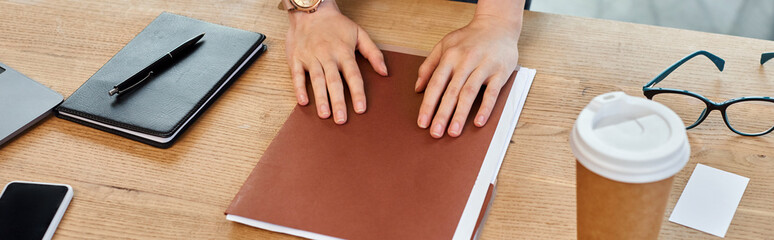 A businesswoman in a modern office is deeply engrossed, hands resting on a book, reflecting a...