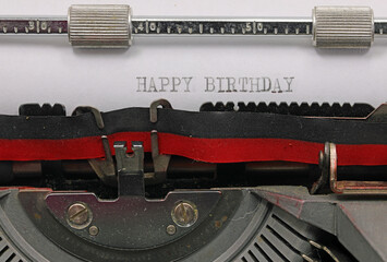 text with black ink HAPPY BIRTHDAY written on the sheet of the old typewriter