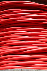 red reel of high voltage electrical cable used for transporting electricity from a power plant