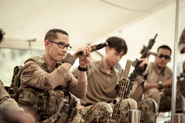 Soldiers in camouflage uniforms planning on operation in the camp, soldiers training in a military...