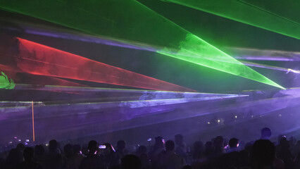 Crowd of people admiring the laser show in the night