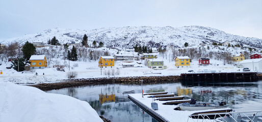 Scenic view of traditional norwegian houses near the waterside of the harbor of Lødingen in...