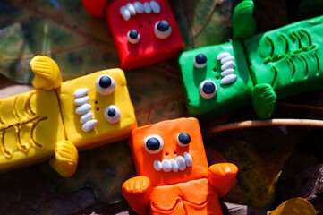 Fototapeta premium Toy monsters lie on autumn leaves. Halloween decorations.