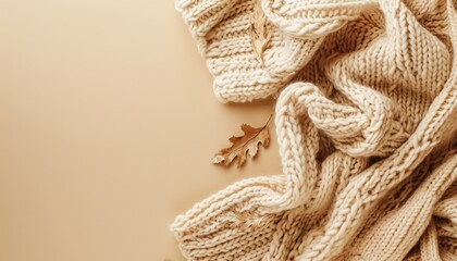 Beige knitted blanket on background with copy space Autumn winter template Flat lay top view