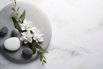Composition of spa stones and white flowers on a marble surface