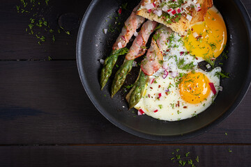 Keto breakfast. Fried eggs  with asparagus in bacon and toast. Top view, flat lay - 782317780