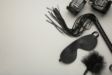 Set of erotic toys for BDSM on grey background. The game of sexual slavery with a whip, gag and leather blindfold. Intimate sex games - obrazy, fototapety, plakaty