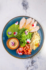 Healthy Lunch Plate With Grilled Chicken, Salad, Avocado, Couscous on Blue Plate