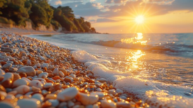   A beach dotted with numerous white rocks borders a tranquil body of water Sun sets behind, painting the sky with warm hues
