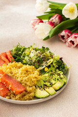 Delicious healthy breakfasts, bulgur porridge with red salmon fish and a salad mix with fresh vegetables, avocado and various seeds, a healthy balanced breakfast with fats, fiber and protein