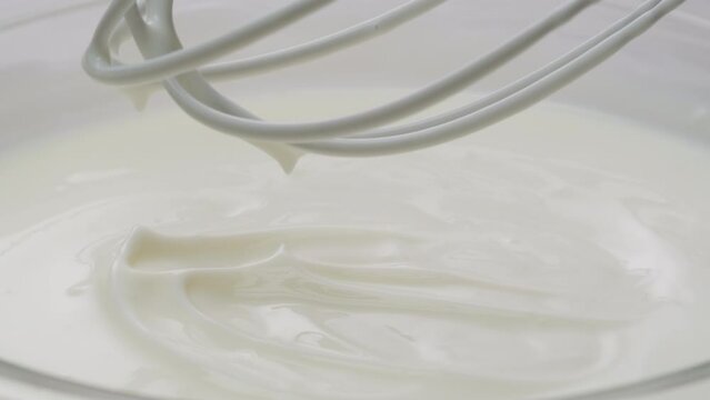 White creamy sauce texture close-up. Dipping and whisking by corolla a white yogurt macro. Dairy products concept. 