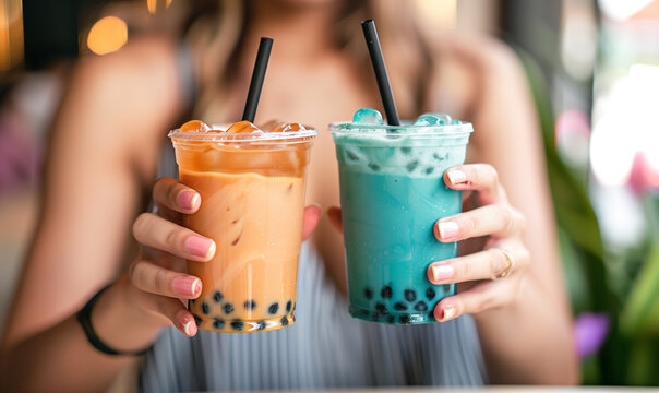 two women hands hold boba milk tea and ceers 