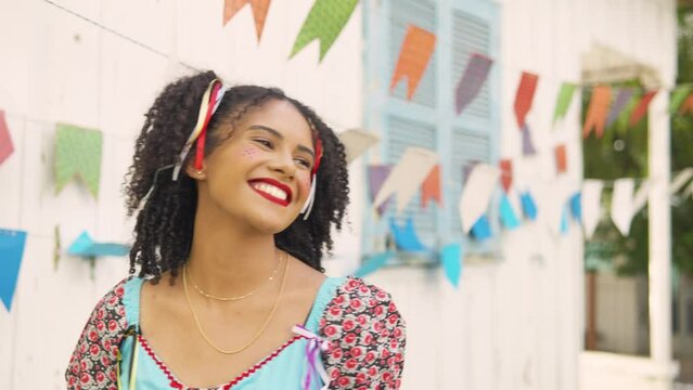 Festa Junina: party in Brazil, cheerful black woman dancing at arraial event in caipira style clothes
