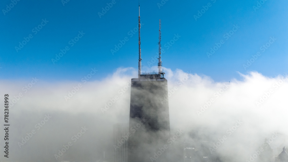 Wall mural John Hancock building in Chicago surrounded by clouds, photo taken from Drone