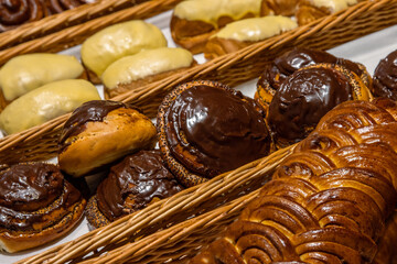 A lot of sweet pastries in baskets on the counter in the food store. Bakery on the buffet table....