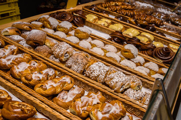 A lot of sweet pastries in baskets on the counter in the food store. Bakery on the buffet table....