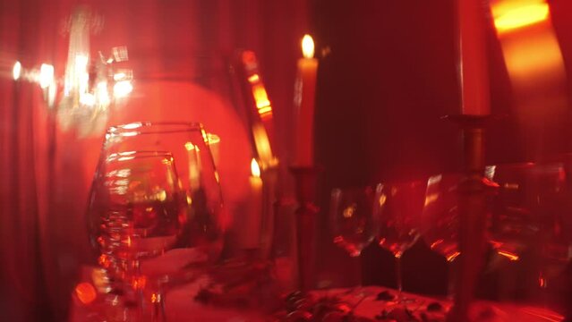empty wine glasses lined up in a red light on a decorative table.