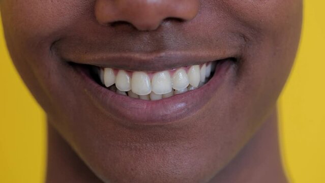 Close up view of young african american man mouth smiling at camera, showing toothy smile, satisfied expression, positive emotion