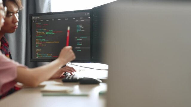 Slow motion back end software developer engineer for computer programming working together on debugging writing computing code, solving complex algorithms display on monitor in office. Burgeoning