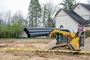 Compact Track Loader Hauling Corrugated Drainage Pipes