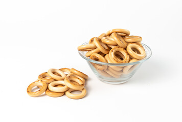 bread rings are laid out in a glass bowl on a white background