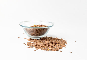 the lentils are in a glass bowl and scattered side by side on a white background