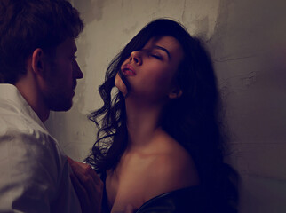 Sexy couple portrait. Man in white shirt hugging his sensual beautiful girlfriend with much emotion. Closeup portrait