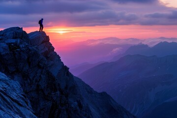 A hiker ascends a ridge in the early morning against the mountain backdrop