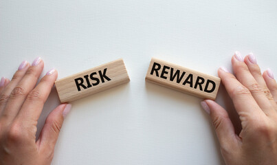 Risk or Reward symbol. Concept word Risk or Reward on wooden blocks. Businessman hand. Beautiful...