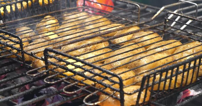Potatoes broils in charcoal brazier. Potatoes are cooked on hot coals in chargrill