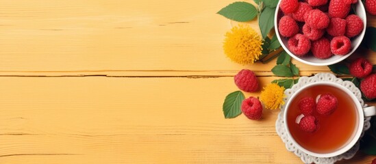 A cup of tea with fresh raspberries and a bright flower