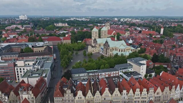 An aerial drone shot of St. Paulus Dom, also known as M&uuml;nster Cathedral, on Domplatz in M&uuml;nster on a sunny day. It is a central and culturally significant area of central M&uuml;nster, Germany. Busy Market