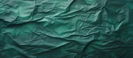 Green crumpled paper texture on dark backdrop