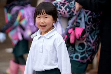 An Asian girl is smiling when her parents pick up her.