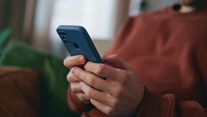 Man hands texting smartphone relaxing at couch close up. Freelancer messaging