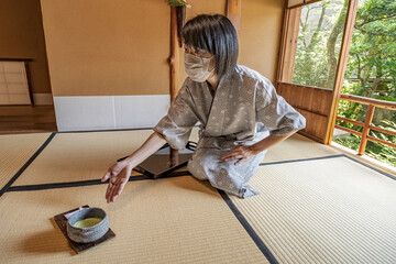Japanese Green Tea Ceremony.
Woman serving traditional Japanese Matcha bowl.
