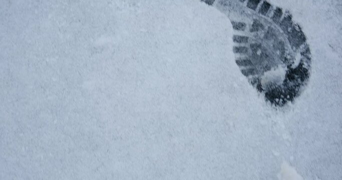 Footprints from the stroller and shoes in the fresh snow. 4k video.
