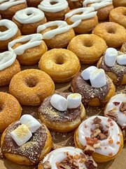 A box of special donuts with marshmallows, chocolate, icing and nuts
